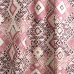 Draped fabric yardage in a painterly diamond print in shades of pink, tan and white.