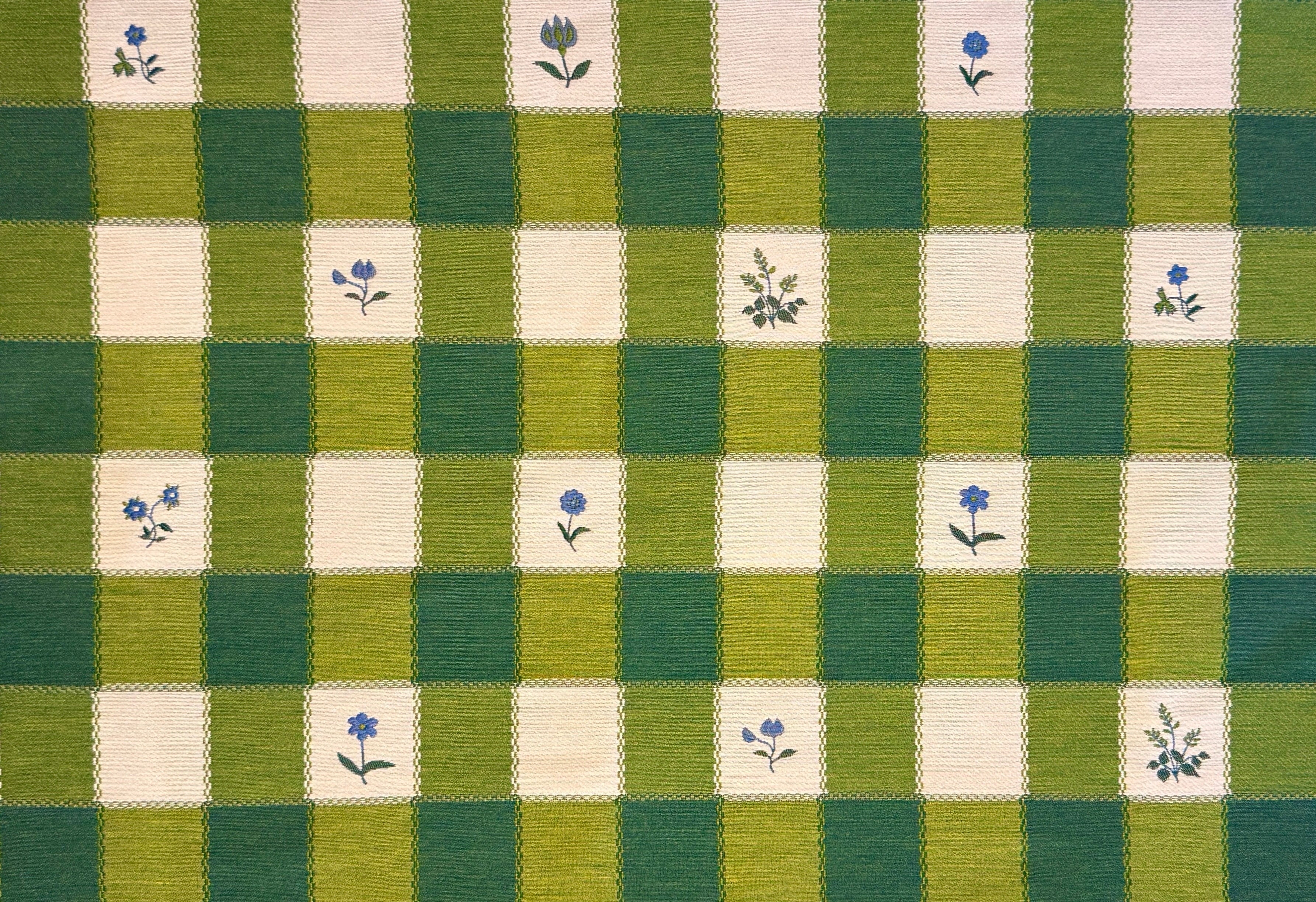 Green and cream checkered fabric with small floral patterns in selected squared