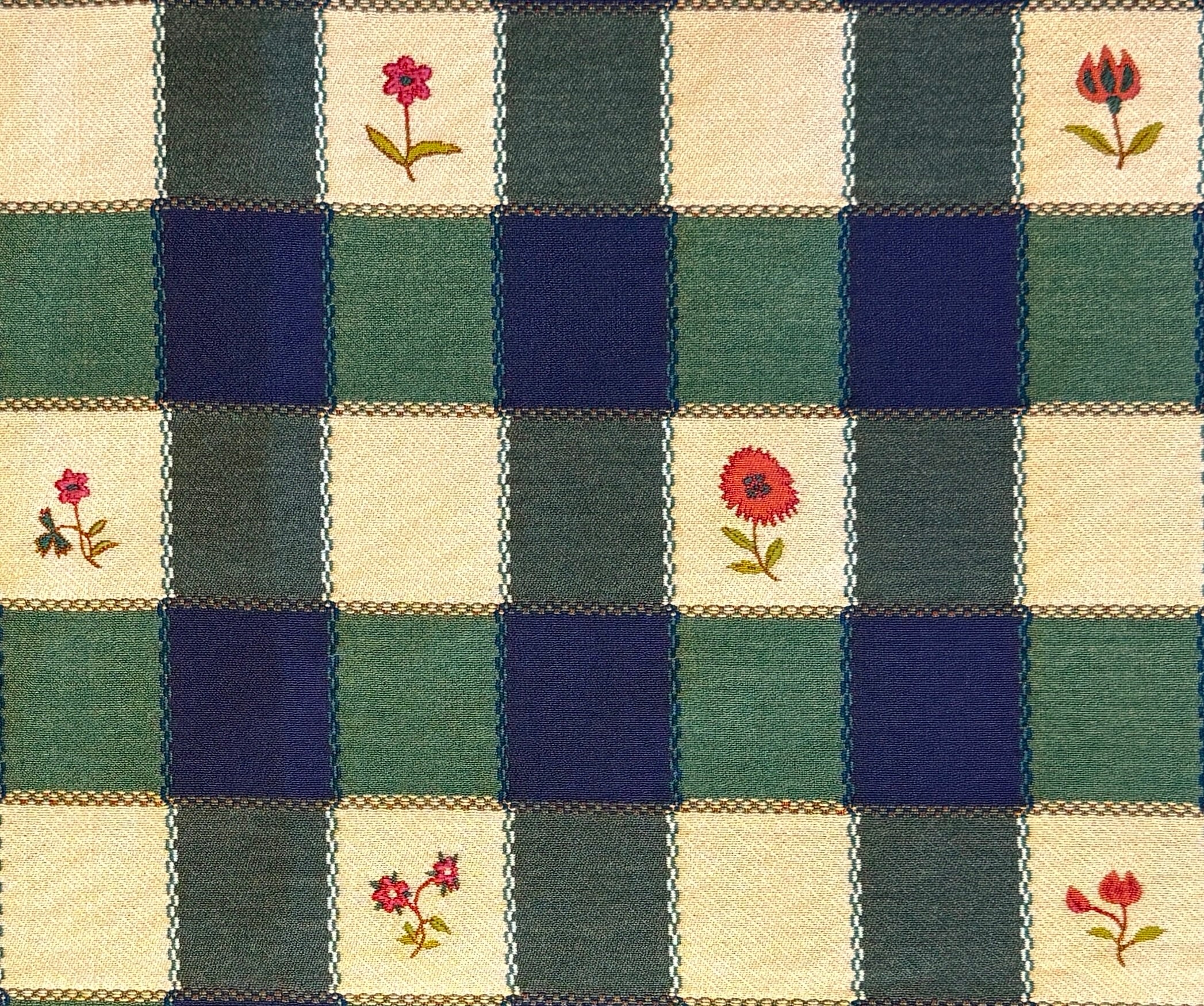 Blue, greena nd cream checkered fabric with floral patterns in alternating squares.