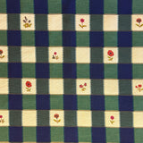 Checkered fabric pattern with floral accents in green, blue, and beige.