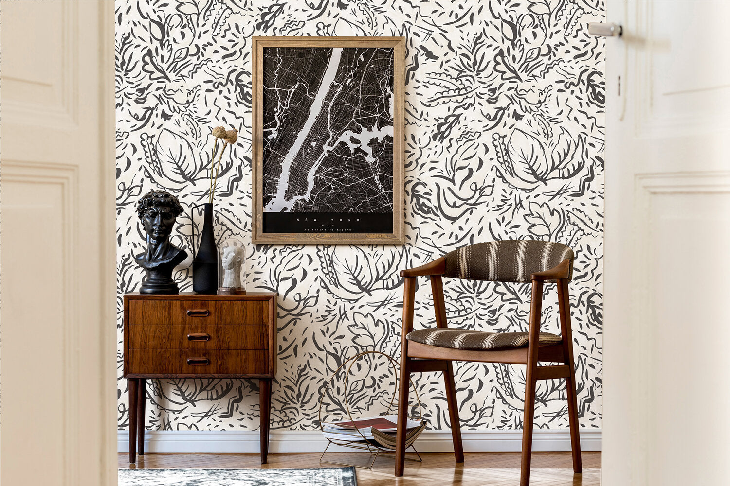 A midcentury inspired living room with a wall papered in a painterly botanical print in black on a white field.