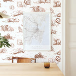 Modernist dining room with a wall papered in a painterly windswept tree print in shades of brown and cream on a white field.