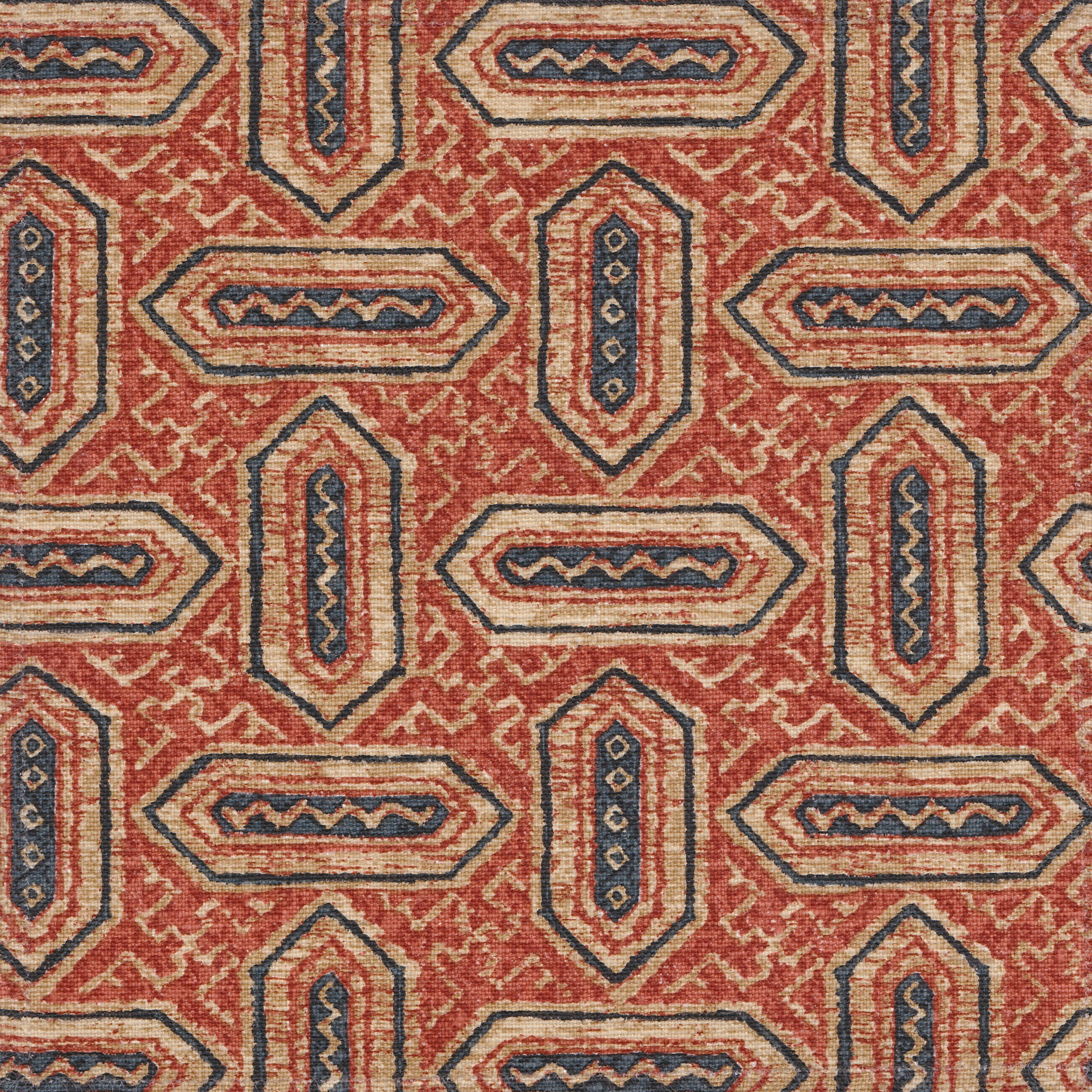 Detail of fabric in a dense geometric print in shades of navy and rust on a tan field.