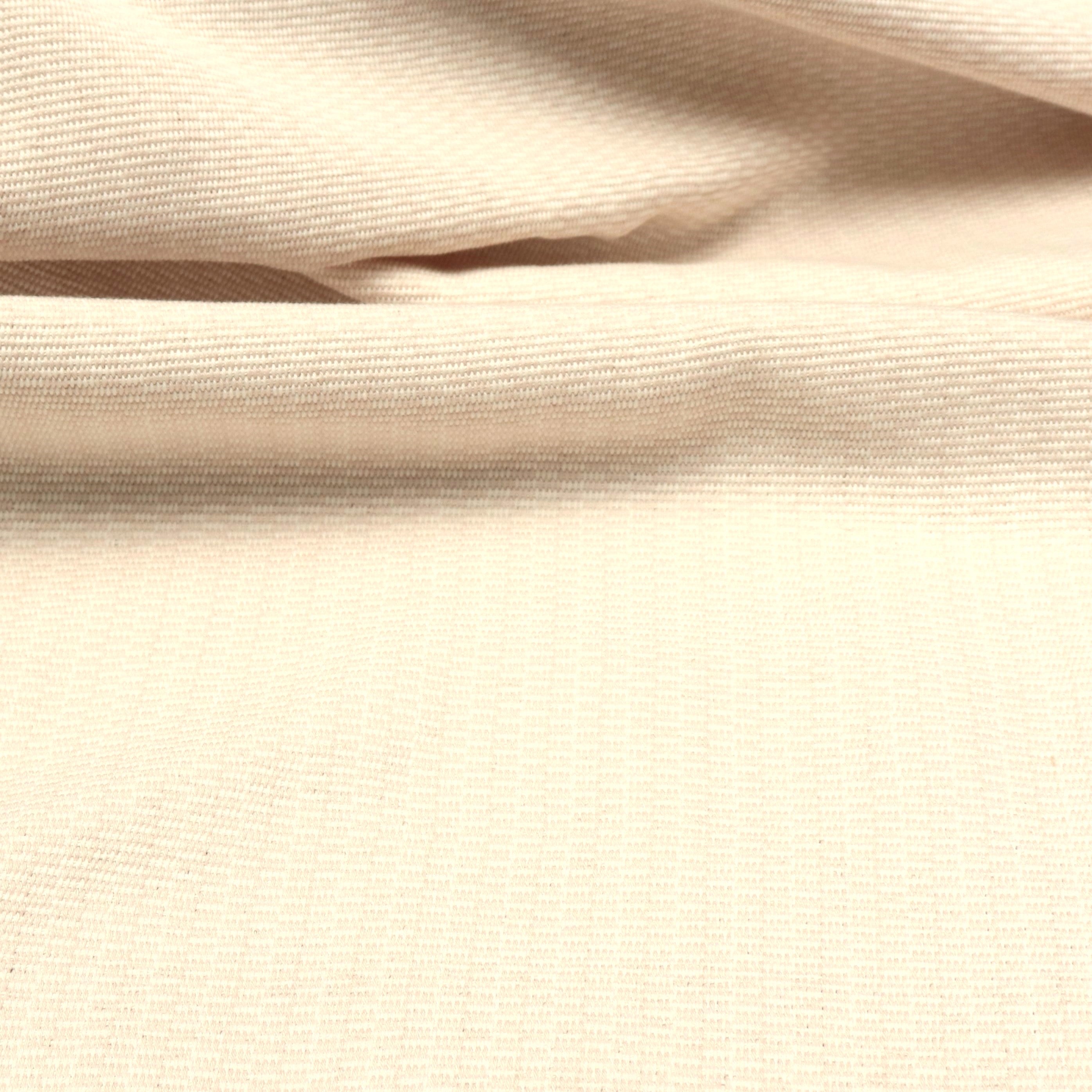 Detail of a draped hand-woven cotton fabric in soft cream. 