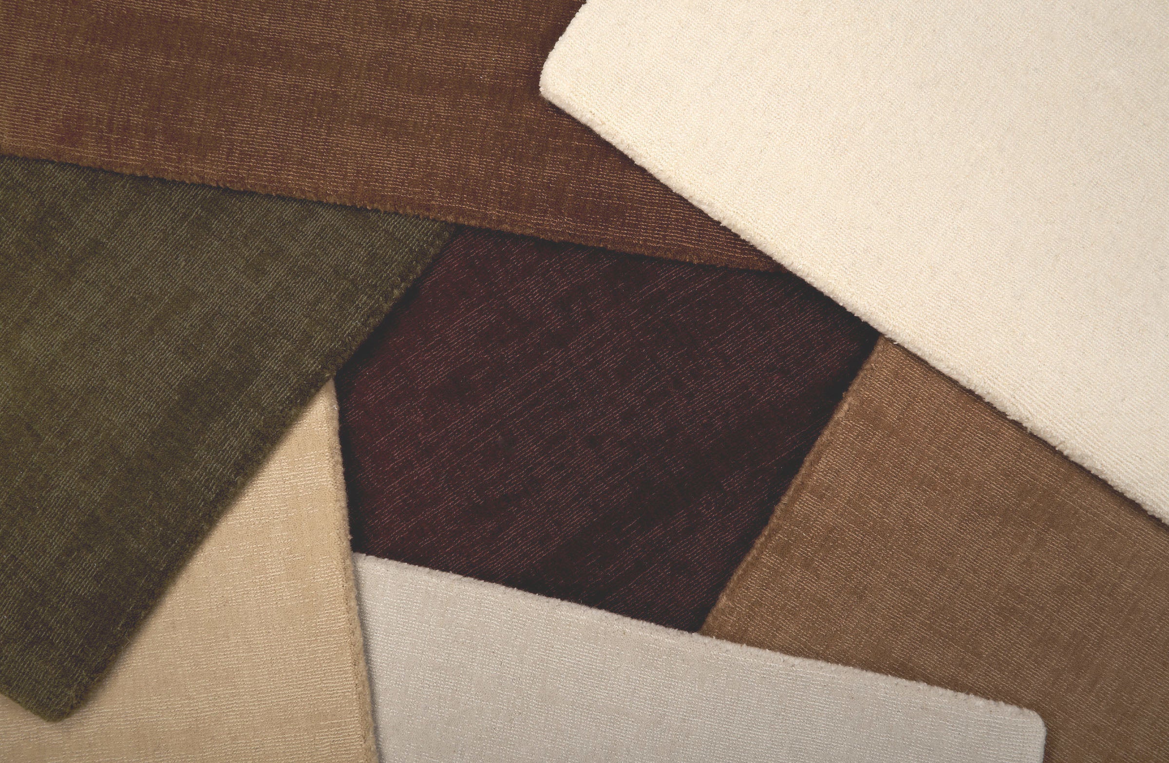 Broadloom carpet samples in an array of solid colors. 
