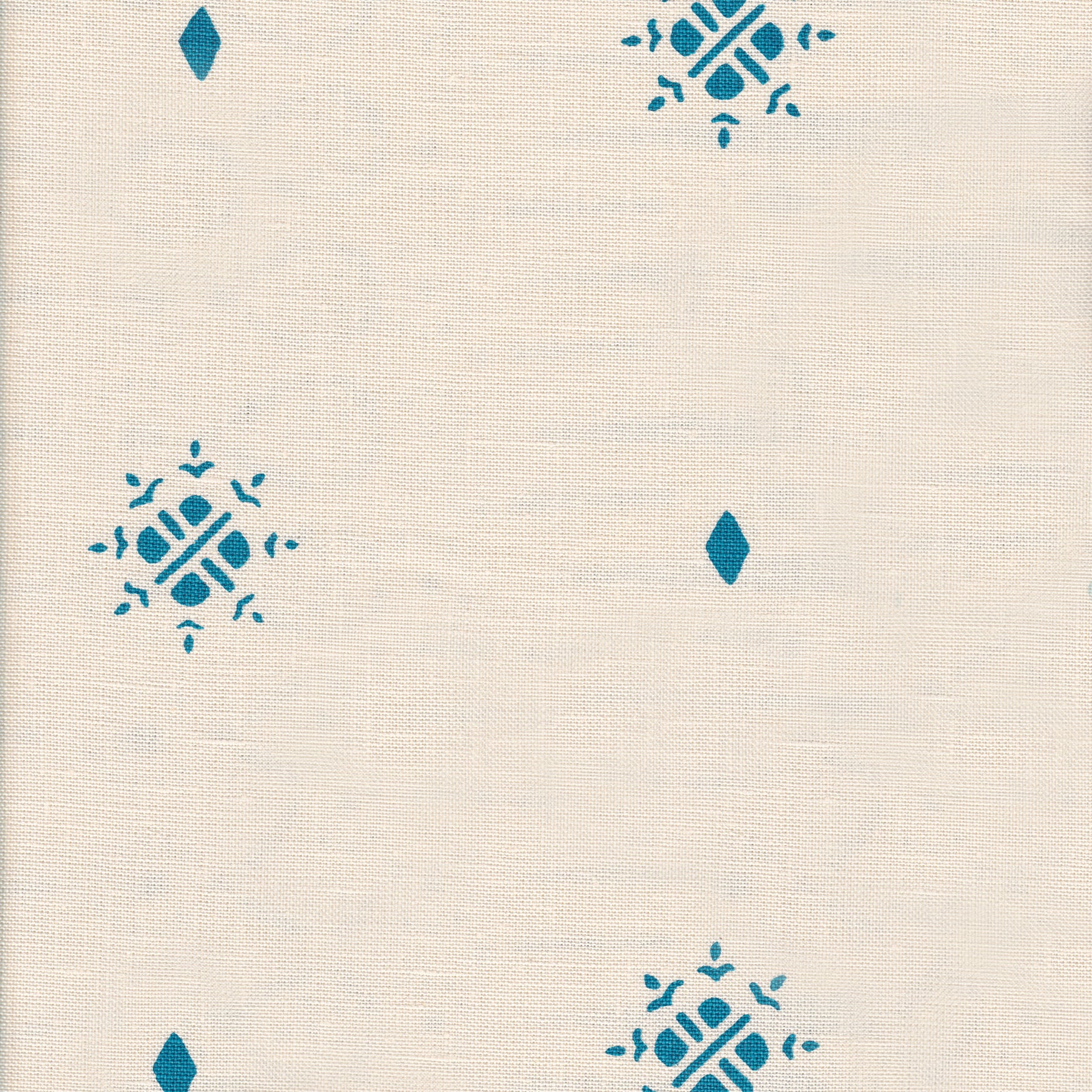 Detail of fabric in a repeating geometric starburst print in turquoise on a cream field.