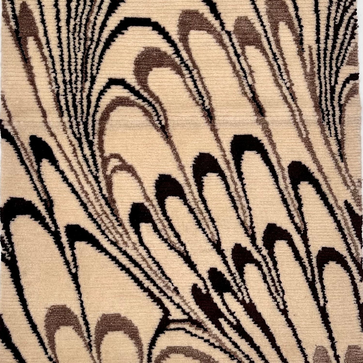 Detail of a rug with an ivory background and abstract pattern in medium brown and dark brown.