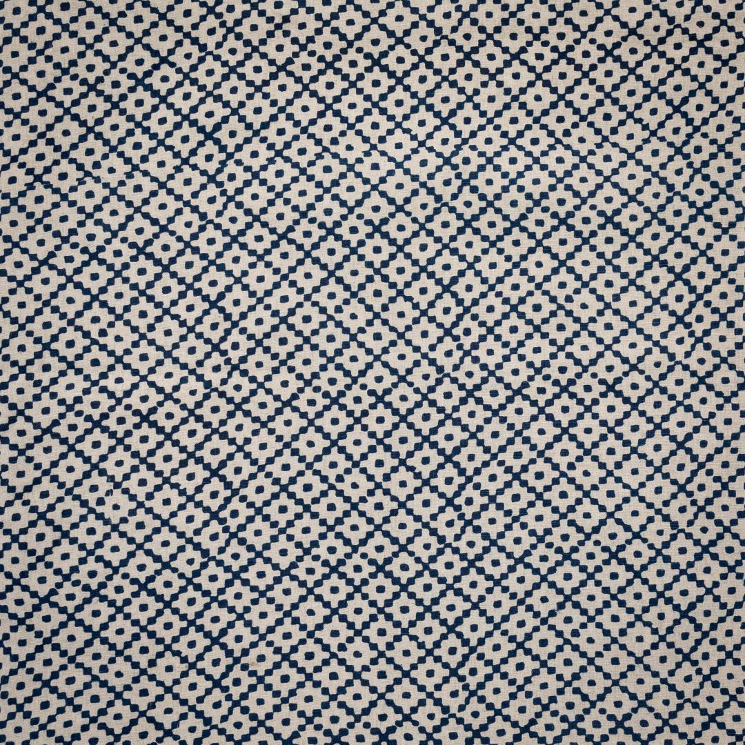 Detail of fabric in a diamond lattice print in navy on a cream field.
