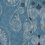 Detail of fabric in a damask print in shades of tan and navy on a blue field.