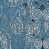 Detail of fabric in a damask print in shades of tan and navy on a blue field.