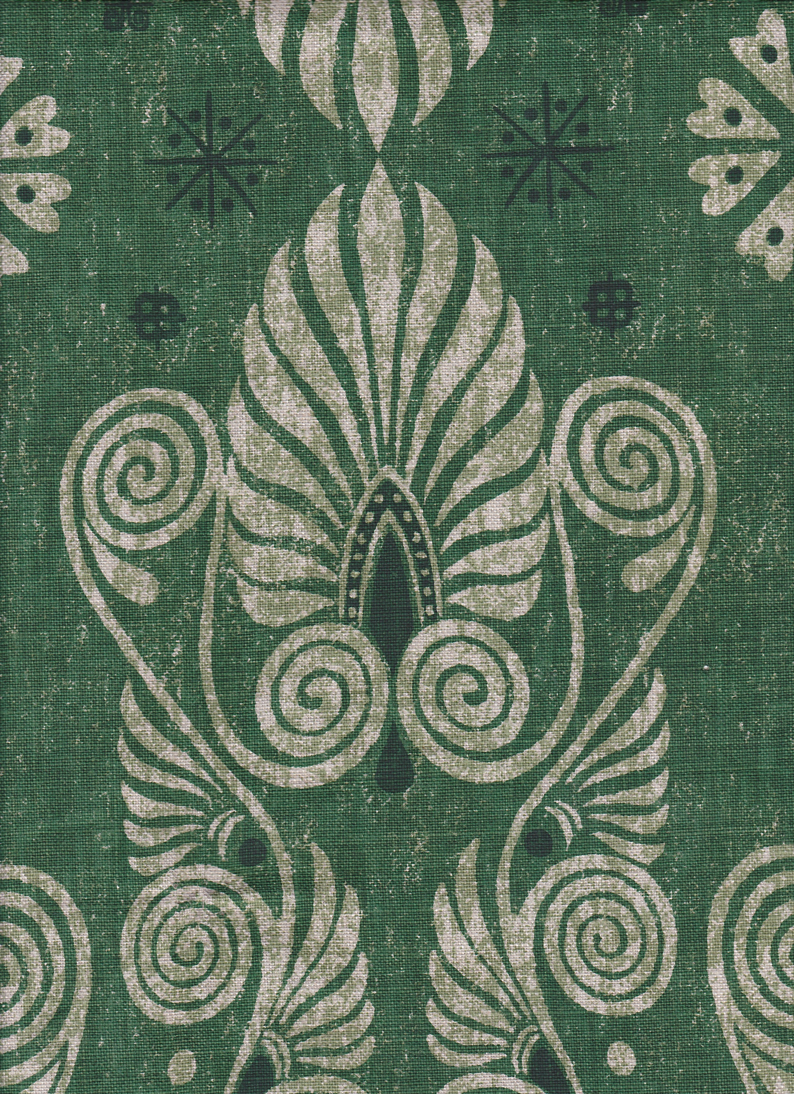 Detail of fabric in a damask print in shades of dark green and cream on a green field.