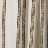 Draped printed fabric in a minimal geometric linear pattern in brown on a cream field.