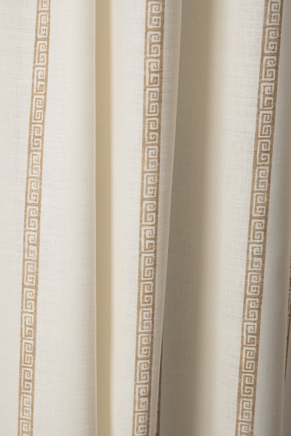 Draped printed fabric in a minimal geometric linear pattern in gold on a cream field.