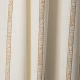 Draped printed fabric in a minimal geometric linear pattern in gold on a cream field.