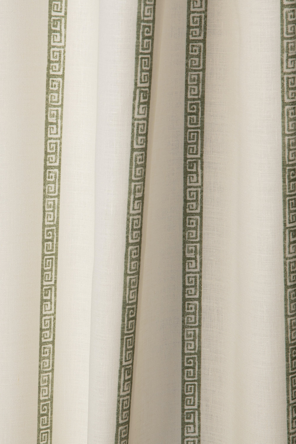 Draped printed fabric in a minimal geometric linear pattern in sage on a cream field.