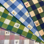 Close-up of checkered fabric with  flowers in various colors.