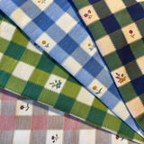 Close-up of checkered fabric with  flowers in various colors.