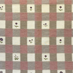 Checkered fabric with small floral patterns on a blush, purple and cream background.