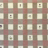 Checkered fabric with small floral patterns on a blush, purple and cream background.