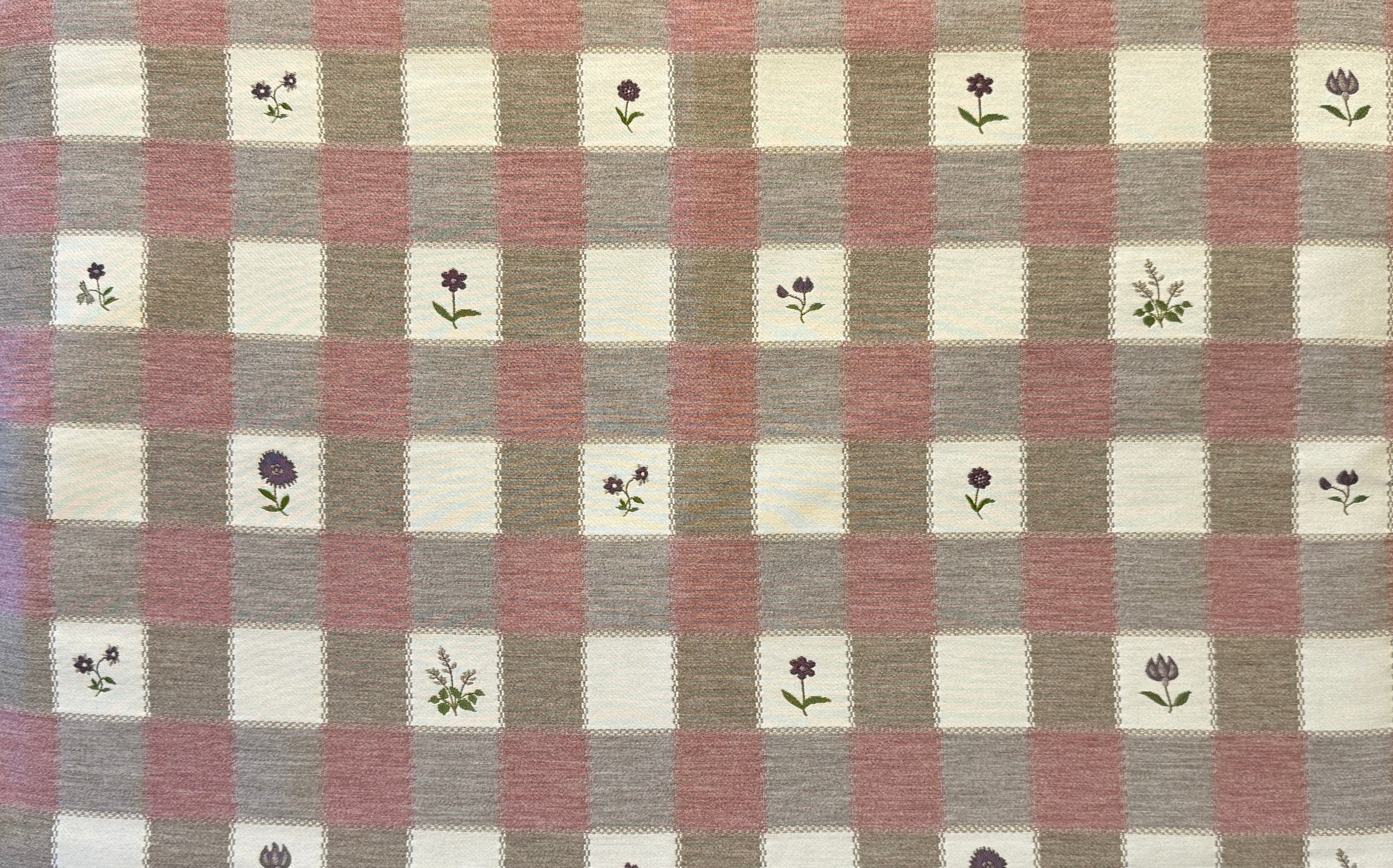 Checkered fabric with small floral patterns on a blush, purple and cream background.