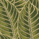 Detail of fabric in a large-scale leaf print in shades of green on a tan field.