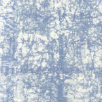 Detail of fabric in a textural splatter print in blue on a cream field.