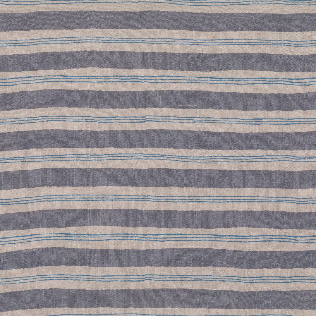 Detail of fabric in a painterly striped pattern in gray and blue on a tan field.