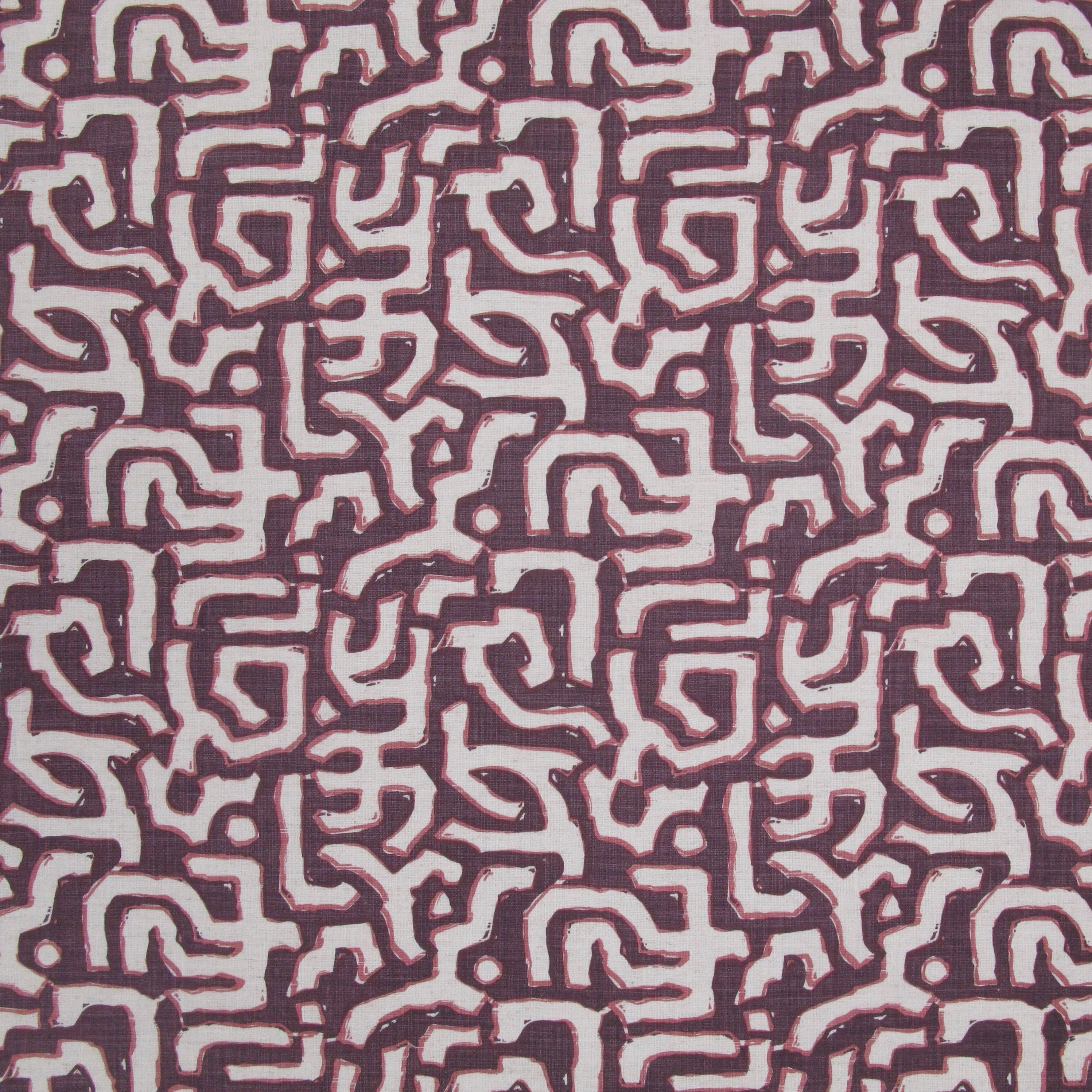 Fabric in an abstract meandering shape print in white and pink on a maroon field.