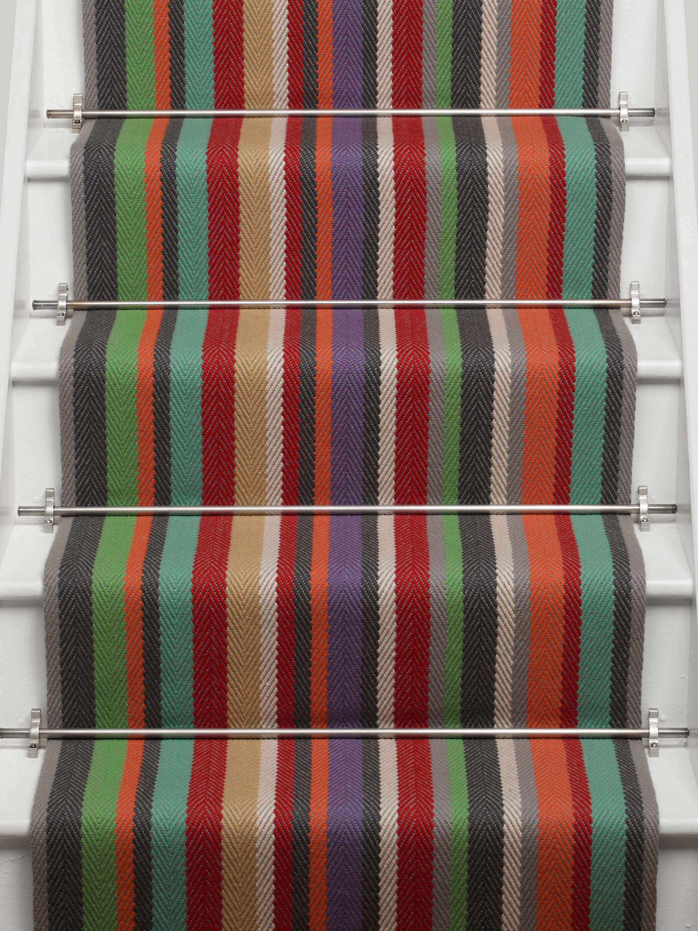 Striped flatweave runner in green blue purple orange red on white staircase