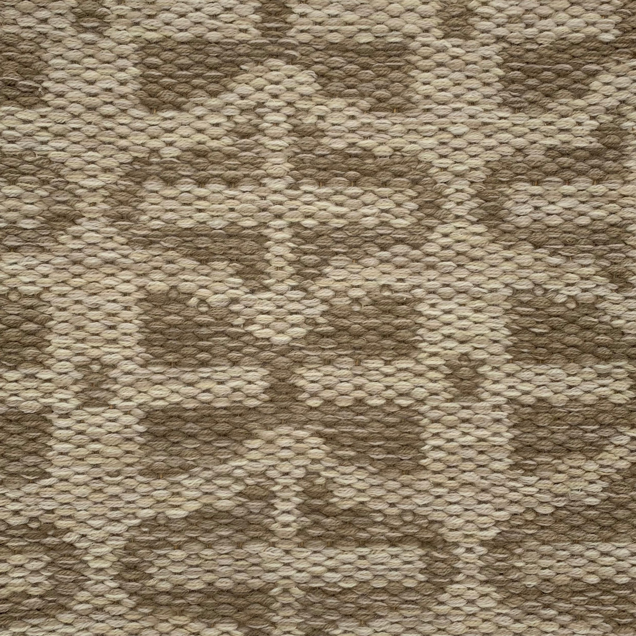 Handwoven rug detail in a contemporary design in brown and beige