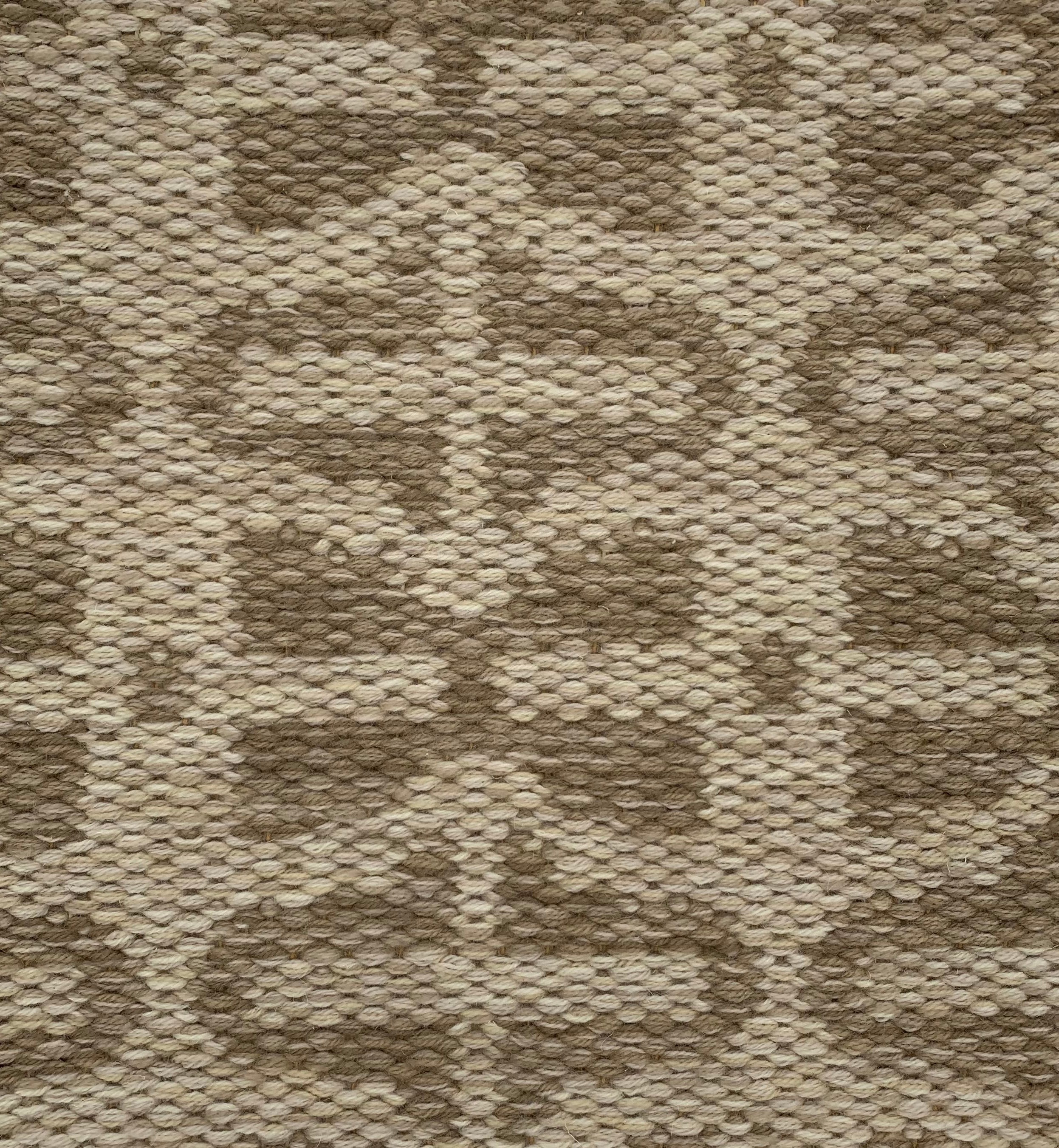 Handwoven rug detail in a contemporary design in brown and beige