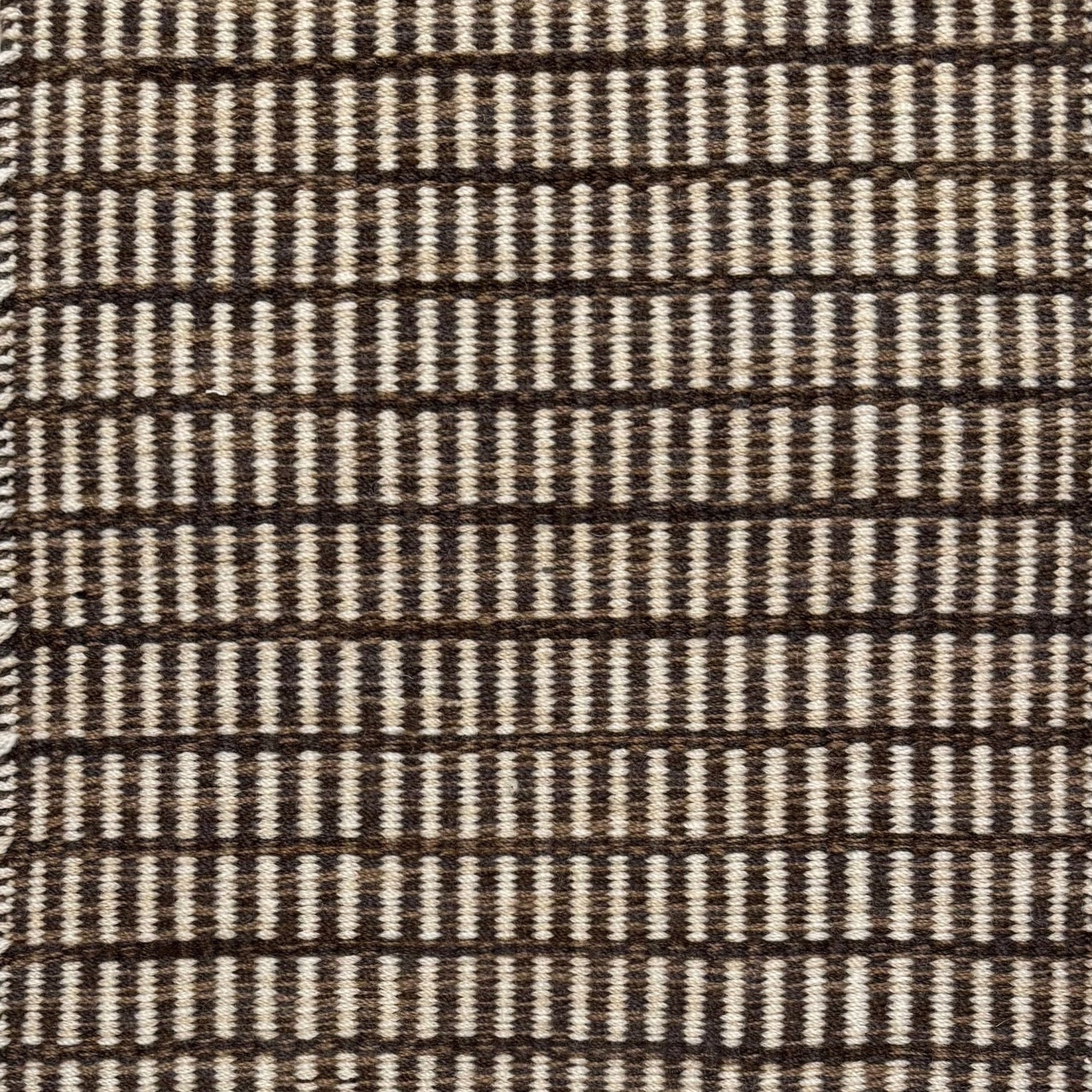 Textured rug with a brown and beige  checker pattern
