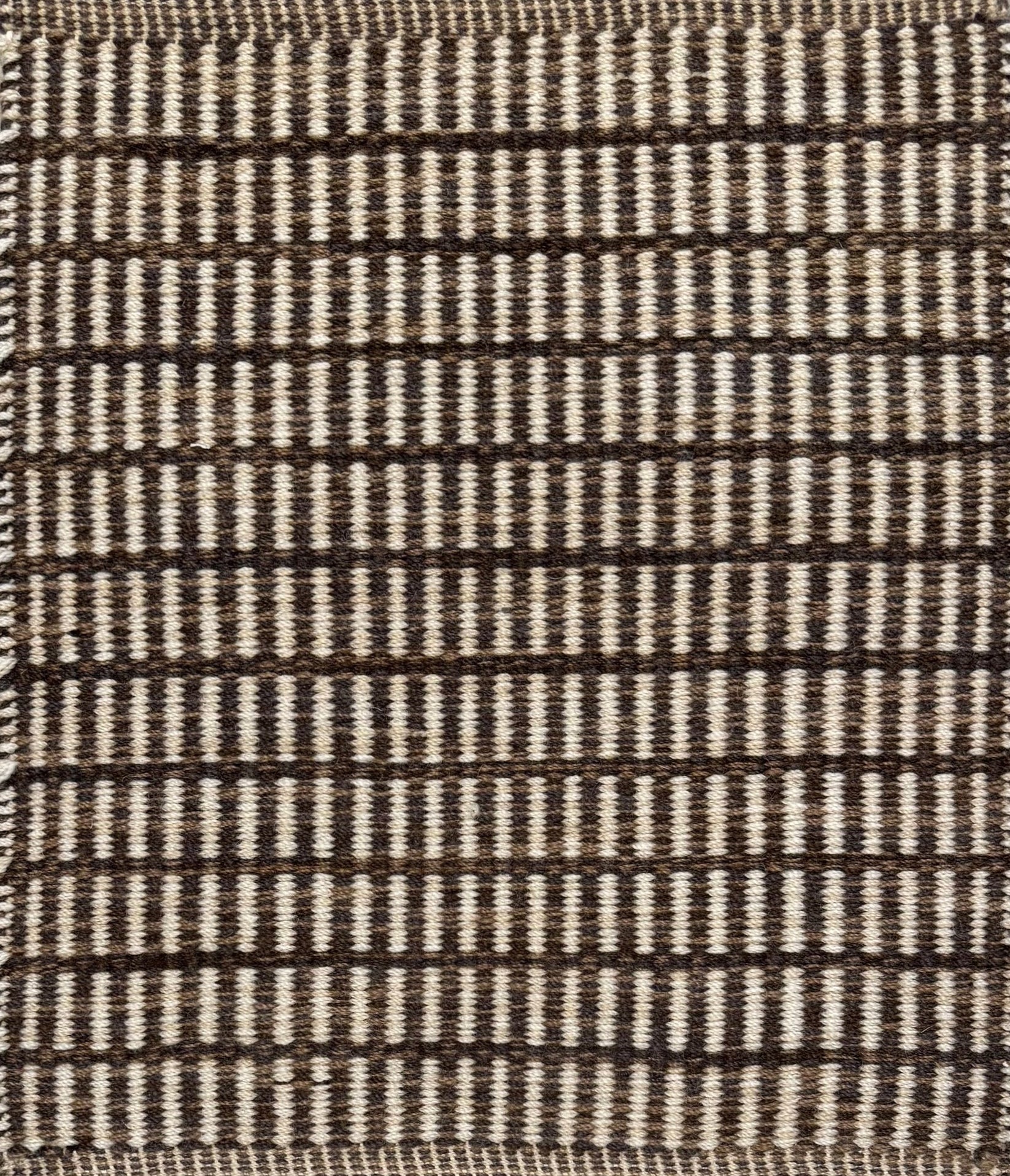 Textured rug with a brown and beige  checker pattern
