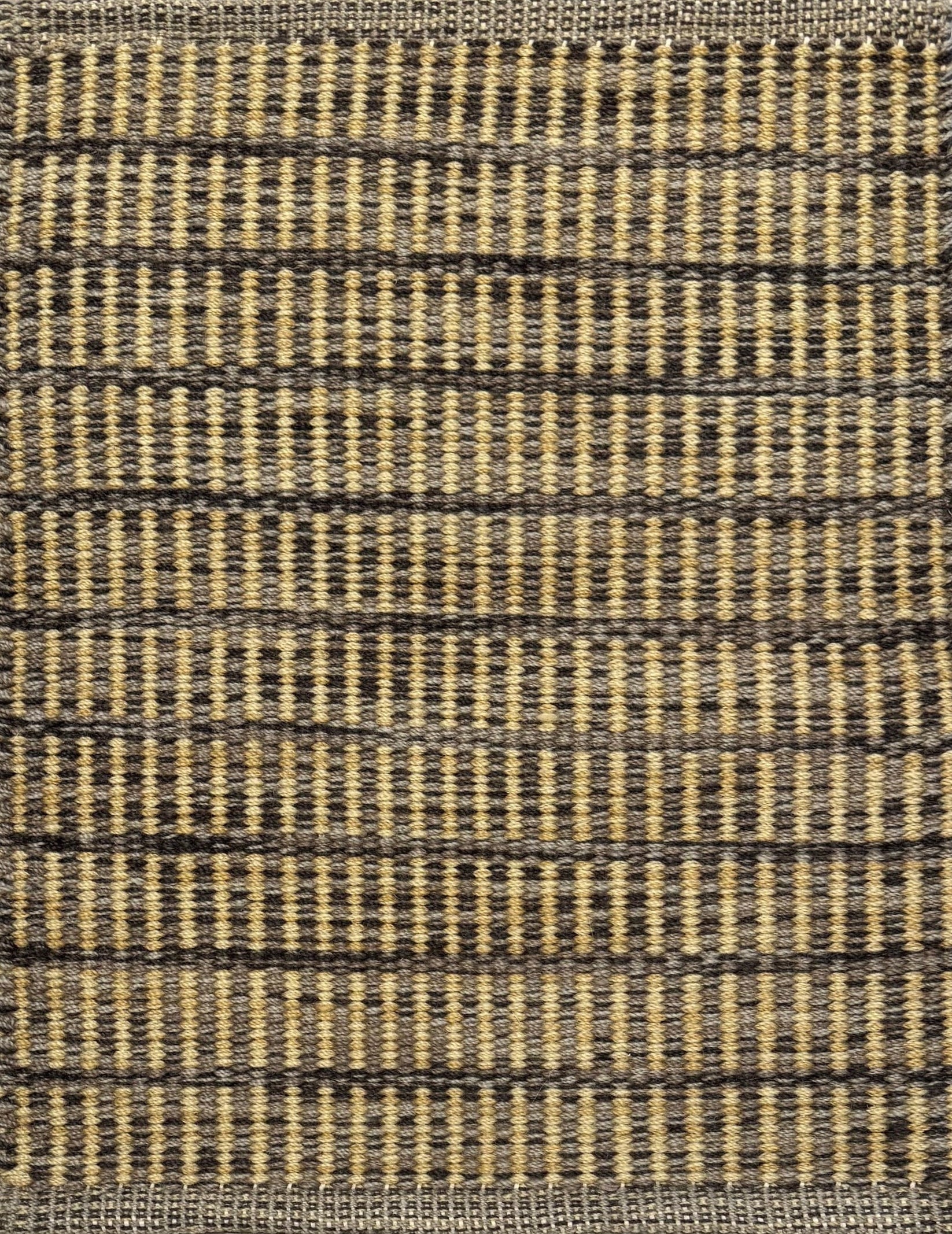 Textured rug with a taupe, brown and tan checker pattern