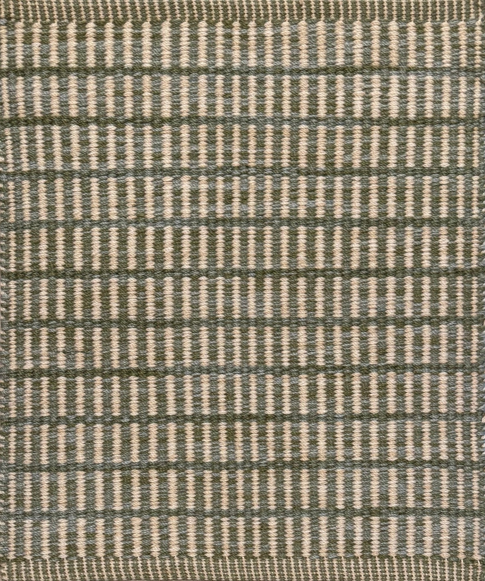 Textured rug with a sage green and beige  checker pattern