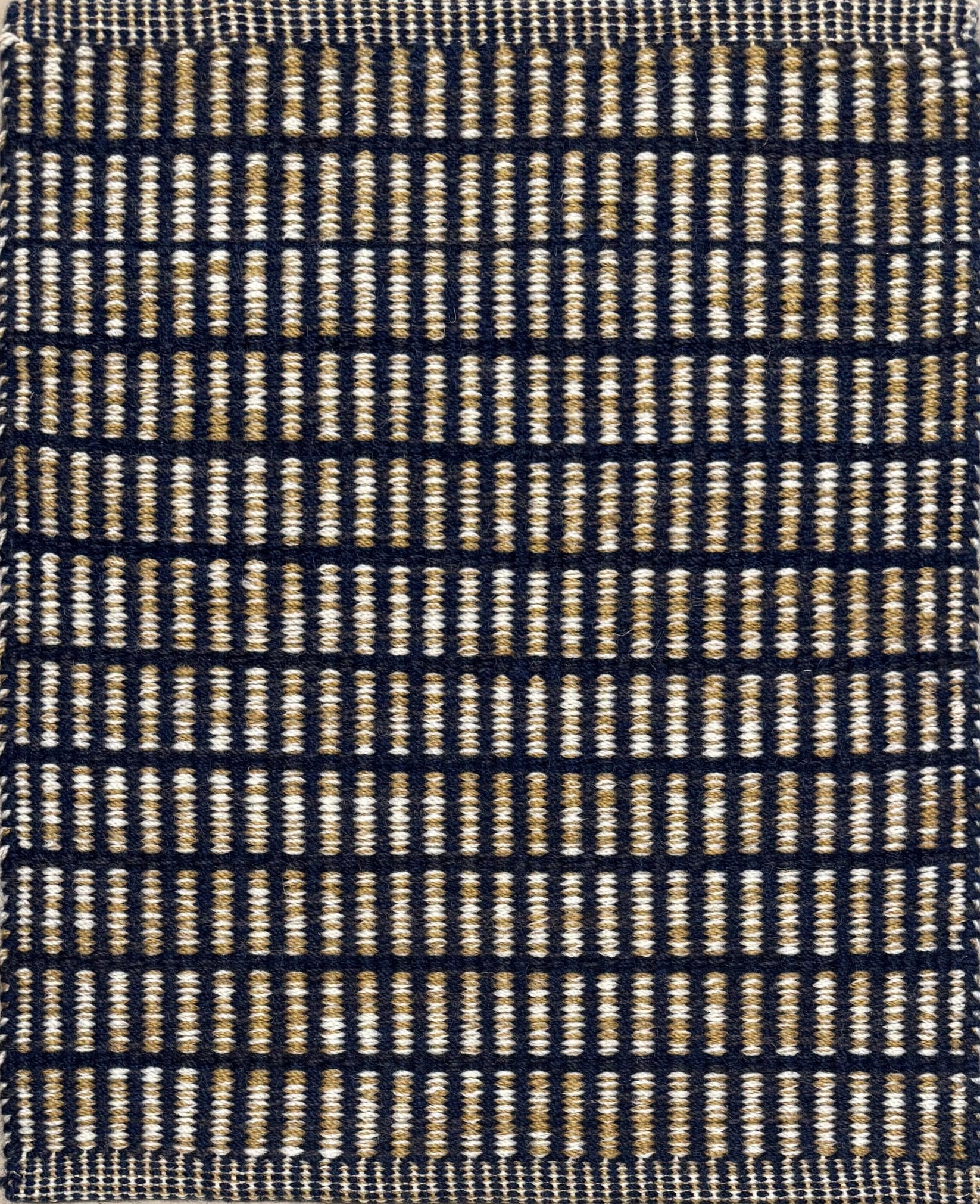 Textured rug with a black and beige  checker pattern