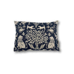 Rectangular throw pillow with a tree at center framed with symetrical lion figures, the back ground is a solid indigo blue, the motif is a natural linen color. 