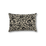 Rectangular throw pillow with a floral scroll filigree pattern in black against a natural linen background. 