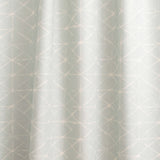 Draped fabric yardage in a mottled lattice print in white on a light blue field.