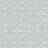 Detail of fabric in a mottled lattice print in white on a light blue field.