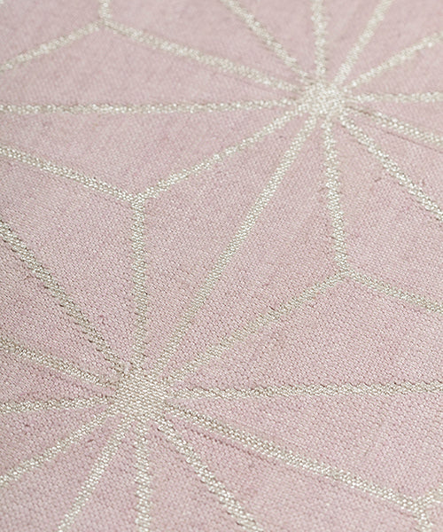Detail of a geometric patterned carpet with silver lattice design on a light purple background