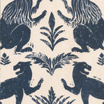 Close-up of wallpaper in a lion and plant print in navy on a cream field.