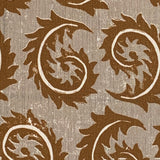 Close-up of fabric in a repeating curved leaf print in white and brown on a tan field.