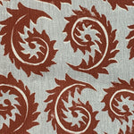 Close-up of fabric in a repeating curved leaf print in white and brown on a gray field.