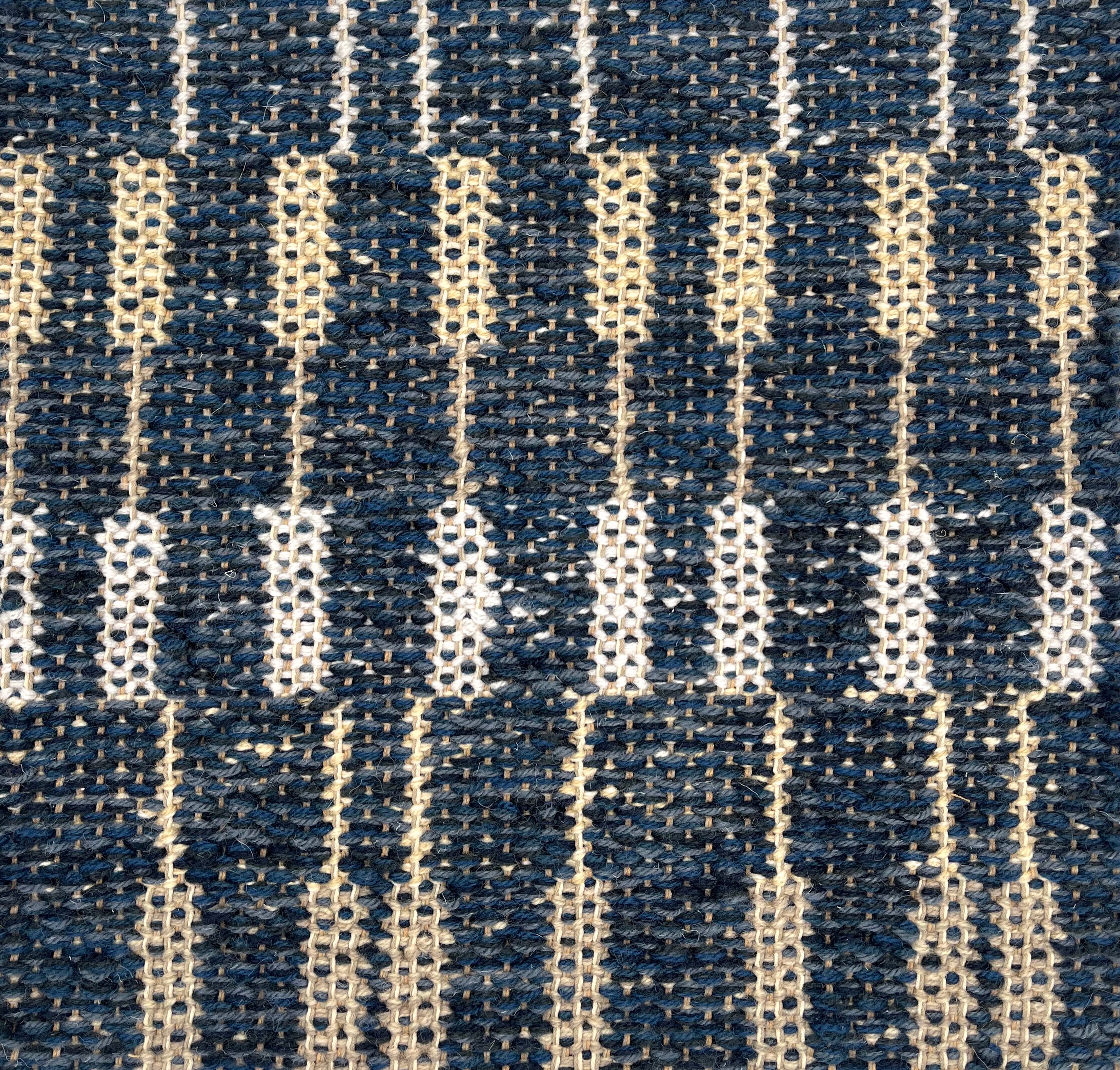 Handwoven rug detail in a contemporary stripe design in blue and cream