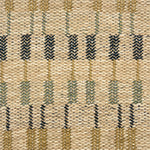 Handwoven rug detail in a contemporary design in tan, green and black