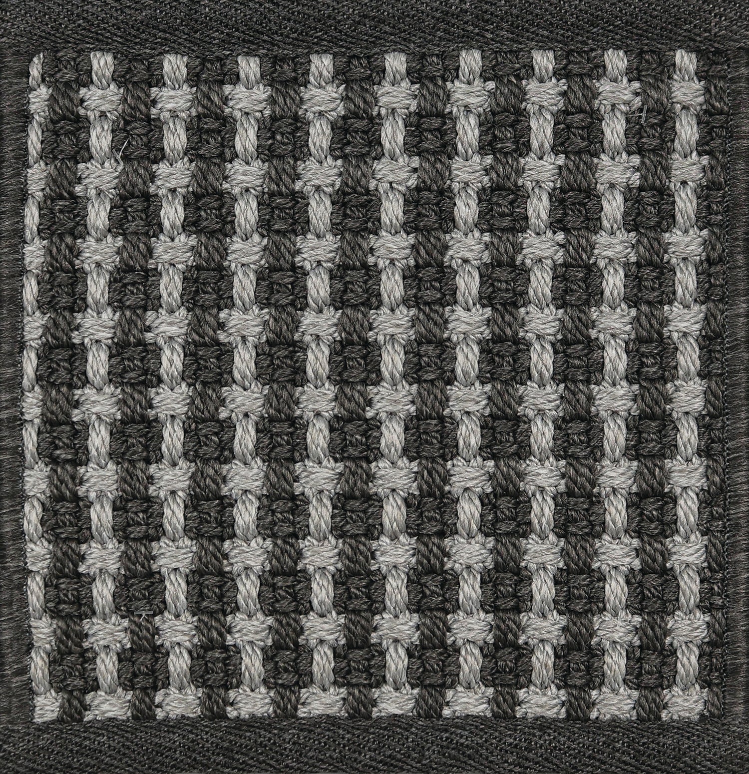 Textured woven outdoor carpet a basketweave design in black and grey.