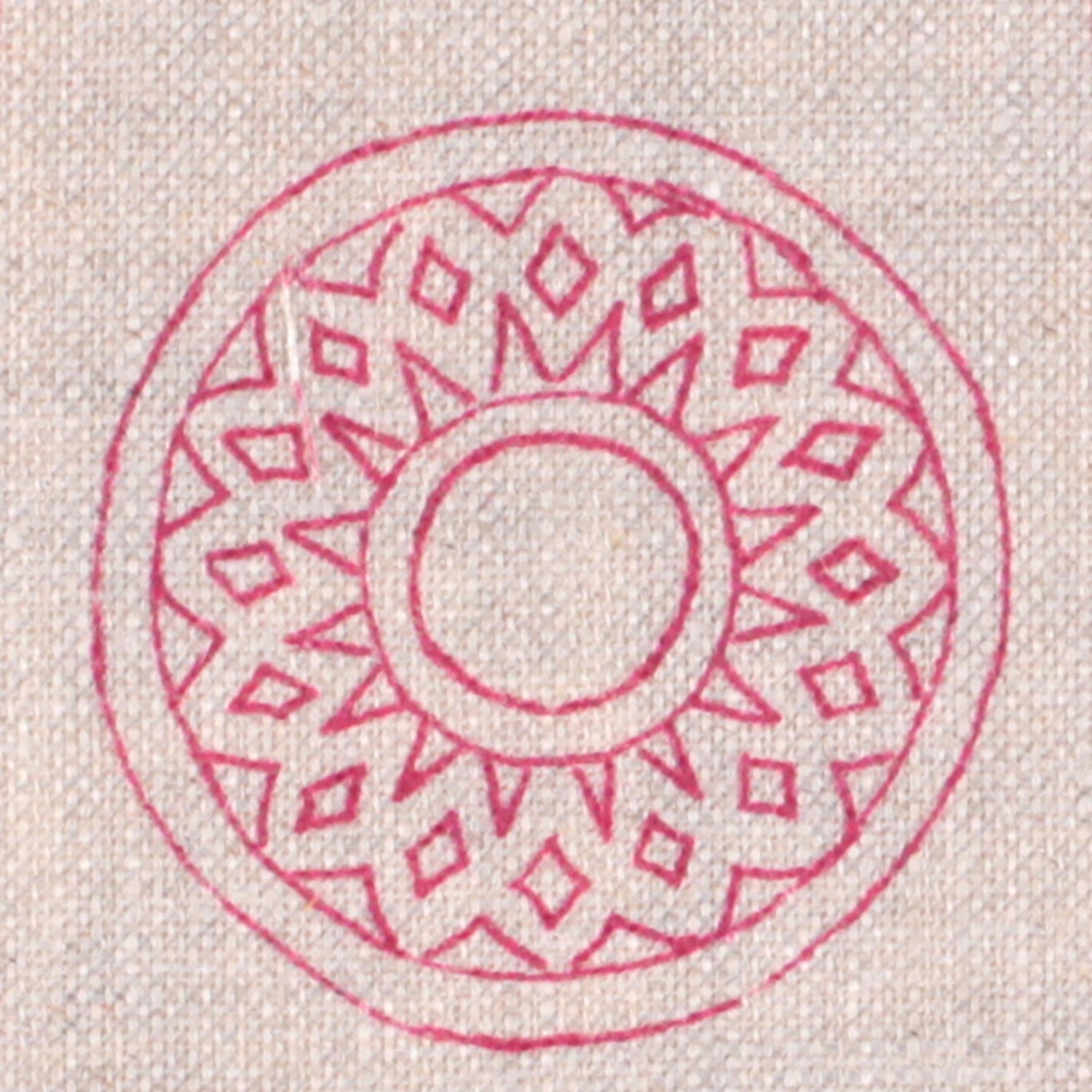 Detail of fabric in a repeating circular geometric print in fuchsia on a cream field.