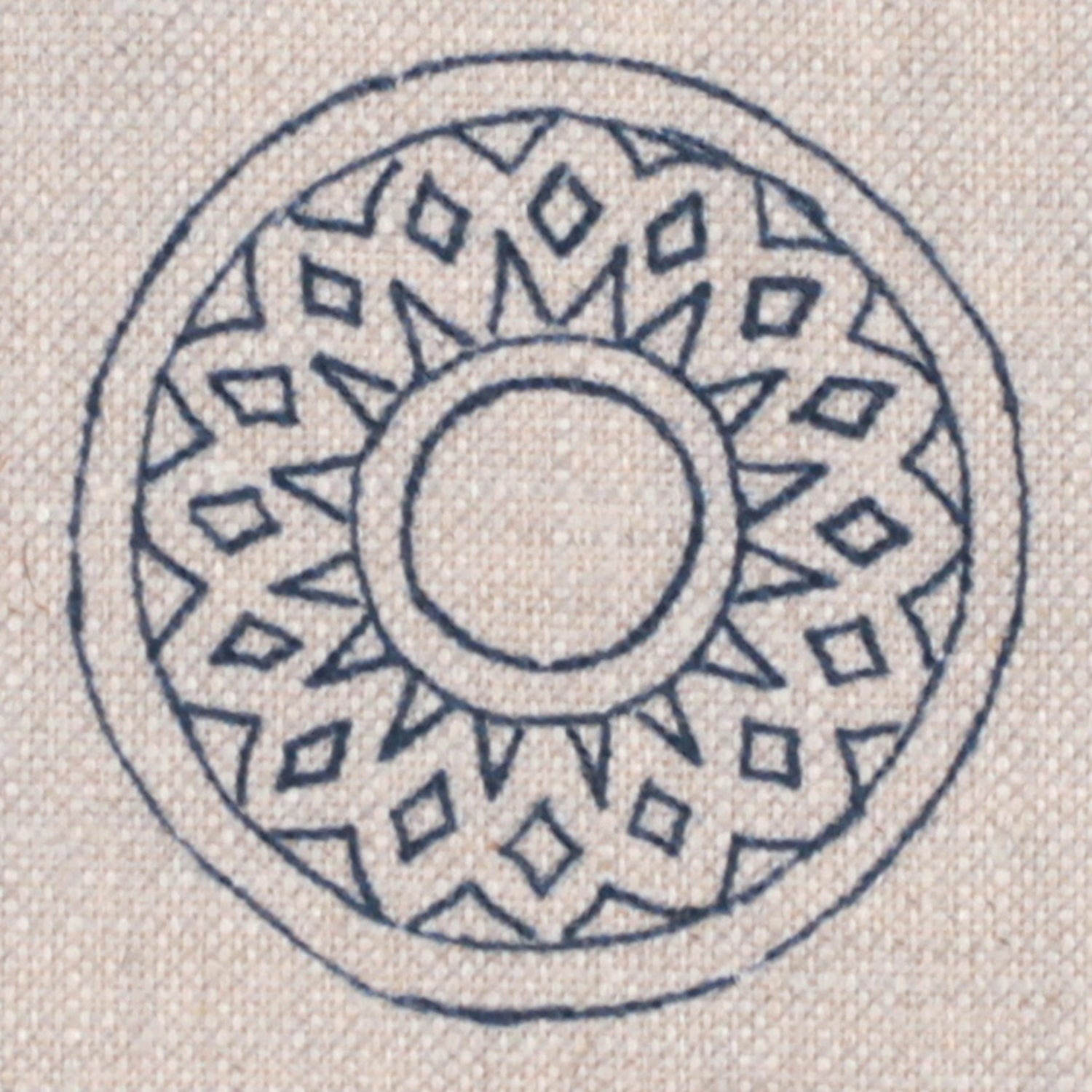 Detail of fabric in a repeating circular geometric print in navy on a tan field.