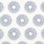 Detail of fabric in a repeating circular geometric print in navy on a white field.